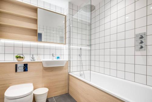 Un baño con bañera, inodoro y lavabo. en Digbeth Luxury Apartment, en Birmingham