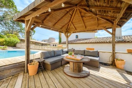 a patio with a couch and a table on a wooden deck at Loft 50m² Au Calme Avec Vue in Les Adrets de l'Esterel