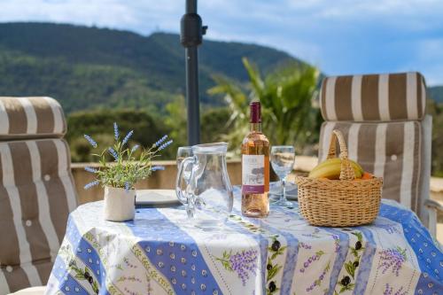 a table with a bottle of wine and a basket of fruit at Loft 50m² Au Calme Avec Vue in Les Adrets de l'Esterel
