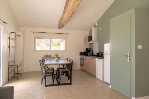eine Küche mit einem Tisch und Stühlen im Zimmer in der Unterkunft La Vie En Gîte (La Grange & Spa) in Sainte-Florence