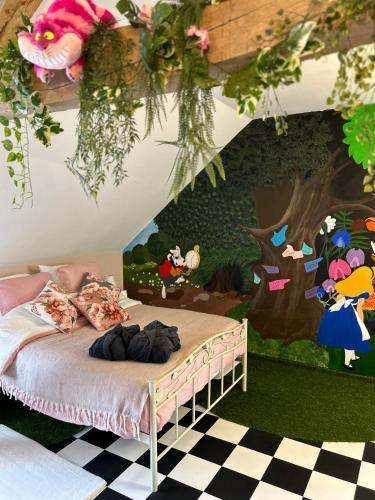 a bedroom with a bed with a painting on the wall at Le Terrier d Alice et du lapin in Floyon