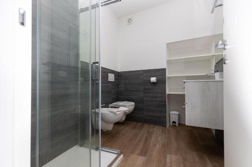 a bathroom with a toilet and a glass shower at Piazza del Lago Suites - Menaggio in Menaggio