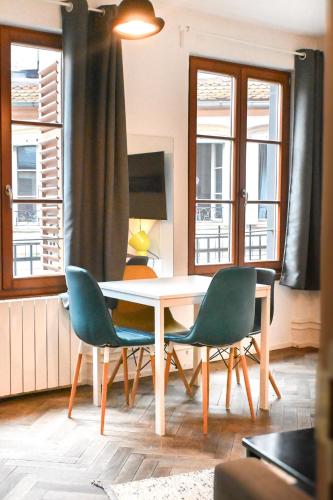 une salle à manger avec une table et deux chaises dans l'établissement Les Appartements Rue des Veaux - Quartier Cathédrale, à Strasbourg