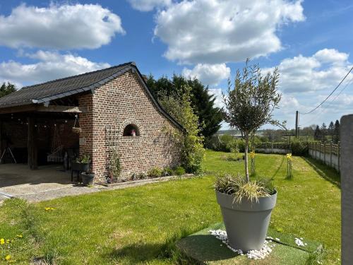 a small brick building with a plant in a yard at Le Terrier d Alice et du lapin in Floyon
