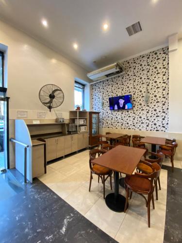 布宜諾斯艾利斯的住宿－HOTEL PALERMO BUENOS AIRES，一间设有桌子的用餐室和墙上的电视