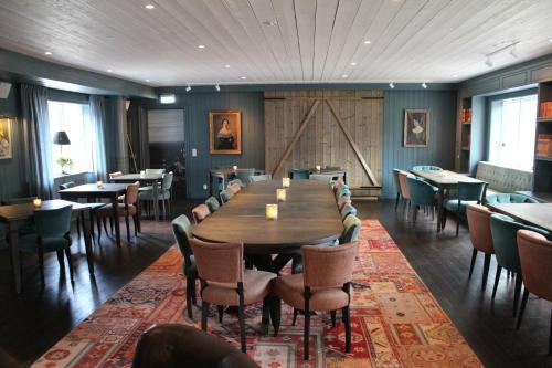 a dining room with a large wooden table and chairs at Olarsgården Hotell in Lindvallen
