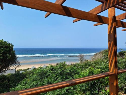 a view of a beach from a wooden fence at Ovuwa Ponta Mamoli in Pedro
