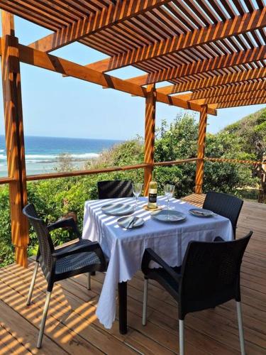 a table on a deck with a view of the ocean at Ovuwa Ponta Mamoli in Pedro