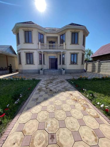 una casa grande con una entrada de piedra delante de ella en Rauza Guest Villa en Bishkek