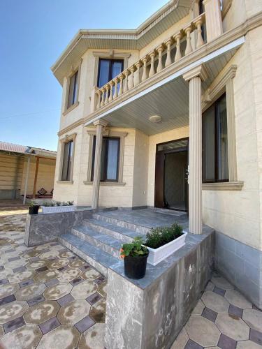 a house with a stone patio in front of it at Rauza Guest Villa in Bishkek