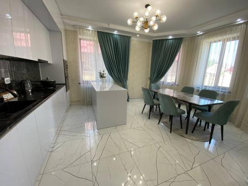 a kitchen and dining room with a table and chairs at Rauza Guest Villa in Bishkek