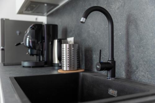 a kitchen sink with a faucet on a counter at Piazza del Lago Suites - Menaggio in Menaggio