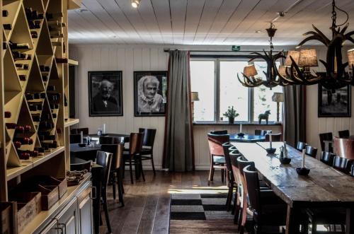 a dining room with a long table and chairs at Olarsgården Hotell in Lindvallen