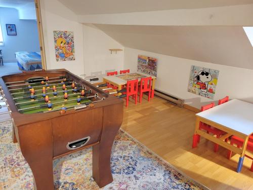 a room with a pool table and tables and chairs at Retraite au lac avec SPA privé et embarcations in Saint Adolphe D'Howard