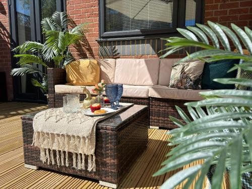 a patio with a table and a couch at Havana House - Luxury Property Near Harbour in Weymouth