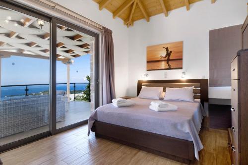 um quarto com uma cama e vista para o oceano em Villa Emily em Tsoukaladhes