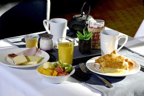 Una mesa con platos de comida y bebidas sobre ella. en Kyriad Annecy Nord - Epagny, en Metz-Tessy