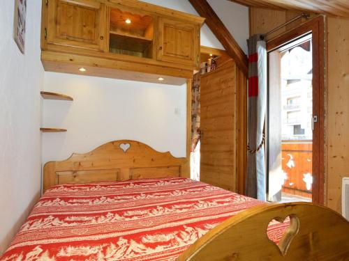 - une chambre avec un lit en bois dans une maison dans l'établissement Spacieux 4 pièces avec mezzanine, balcon et parking, à 2 pas de Super-Châtel - 7 pers. - FR-1-676-25, à Châtel