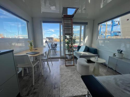 a living room with a table and chairs and a staircase at Tiny lake houses near the beach and centre by Weltevreden Experience in Zeewolde