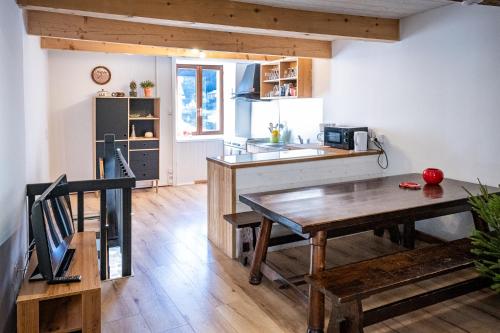 eine Küche und ein Esszimmer mit einem Holztisch in der Unterkunft Bol d'air à Mijanès in Mijanès