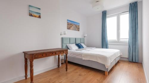 a bedroom with a bed and a desk and a window at Nexo, Sun & Snow in Puck