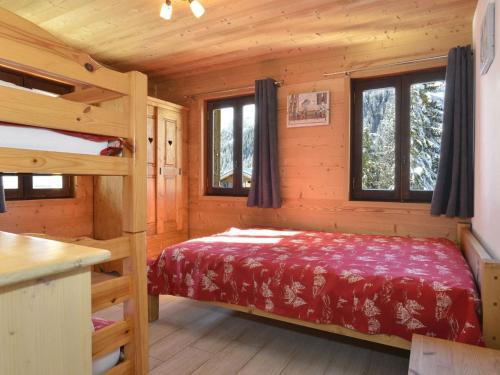 une chambre avec un lit dans une cabane en rondins dans l'établissement Appartement cosy 3 pièces pour 7 pers., Châtel - Balcon, Jardin, Proche centre et remontées mécaniques - FR-1-676-36, à Châtel