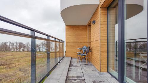 a balcony of a house with a chair on it at Nexo, Sun & Snow in Puck