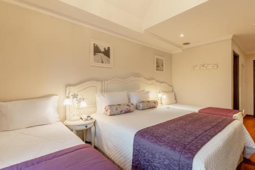 a bedroom with two beds and a nightstand with two beds at Pousada D'Biagy Premium in Campos do Jordão