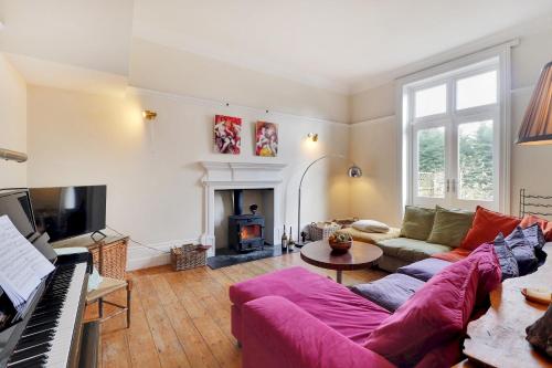 a living room with a couch and a piano at Sanctuary Forest Row countryside village escape Pass the Keys in Forest Row