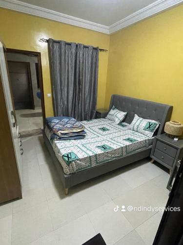 1 dormitorio con 1 cama en una habitación con ventana en Appartement immeuble k rass, en Dakar