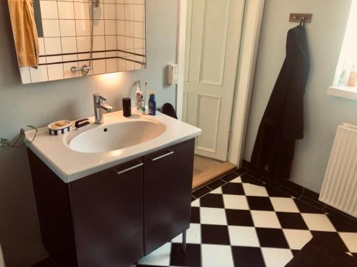 bagno con lavandino e pavimento a scacchi di Stor 2-værelses i baggården a Odense