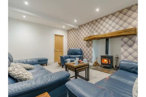 a living room with blue couches and a fireplace at luxury Farmhouse: Hot Tub & Garden in Soutergate