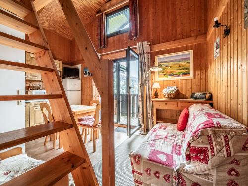 sypialnia w drewnianym domku z łóżkiem i biurkiem w obiekcie Chalet Les Gets, 2 pièces, 6 personnes - FR-1-671-139 w mieście Les Gets