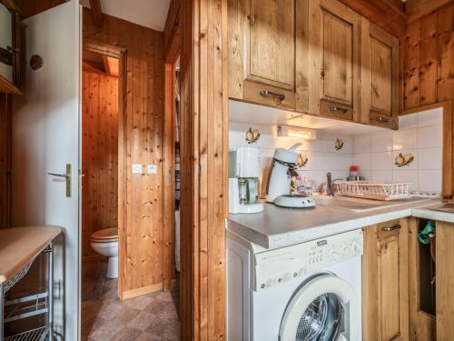 eine Waschmaschine und einen Trockner in einer Küche mit Holzschränken in der Unterkunft Chalet mitoyen Les Gets 6 pers. - Balcon Sud, Garage, Wi-Fi, Animaux admis - FR-1-671-139 in Les Gets