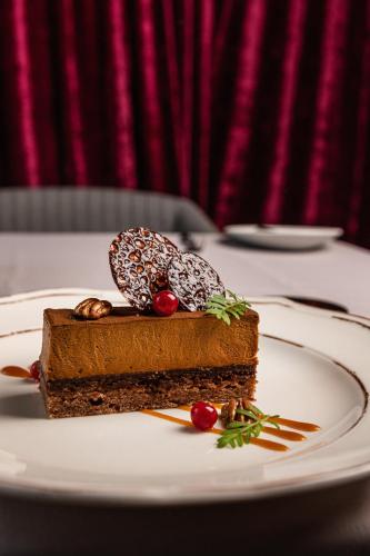 a piece of cake on a plate on a table at Grand Poet Hotel and SPA by Semarah in Riga