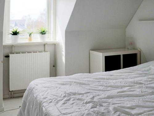 um quarto com uma cama branca e dois vasos de plantas em Holiday home Halmstad XI em Halmstad