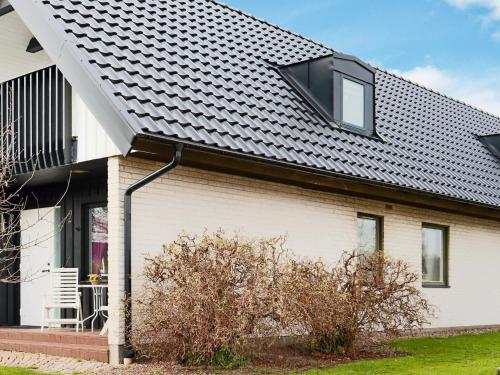 a white house with a black roof at 4 star holiday home in Halmstad in Halmstad