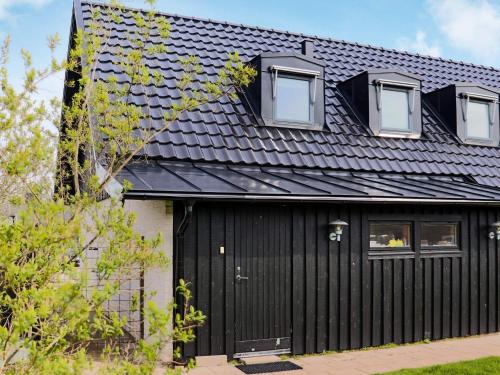 a black house with a black roof at 4 star holiday home in Halmstad in Halmstad