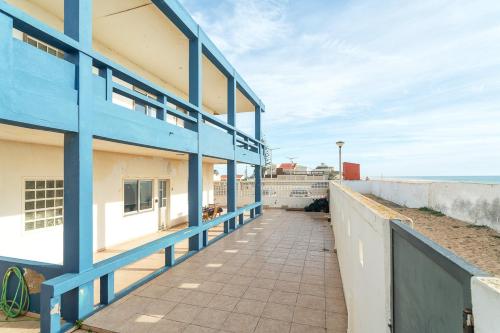 a blue and white building next to the beach at Blife Bandaya private apartment in Faro