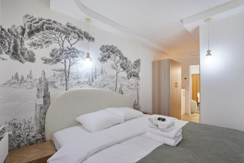 une chambre avec un lit blanc avec un tableau sur le mur dans l'établissement Résidence Montparnasse by Studioprestige, à Paris