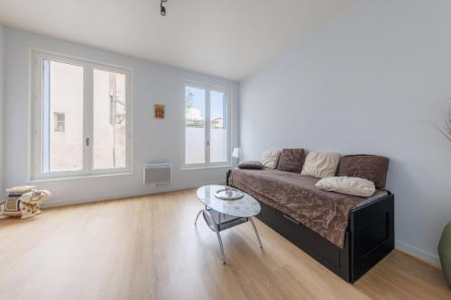 un salon avec un canapé et une table dans l'établissement L'Escale Clermontoise - studio 26m2, à Clermont-Ferrand