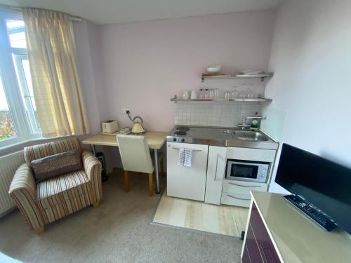 a small kitchen with a table and a stove top oven at WynnStay Studio Apartments in Southend-on-Sea