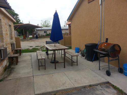 een patio met een tafel, een parasol en een grill bij Star Inn in Karnes City