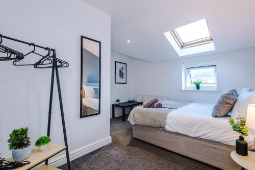 A Comfortable 1-Bedroom Apartment - Sleeps 2 في وارينغتون: غرفة نوم بسرير ومرآة