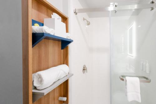 y baño con ducha y aseo con toallas. en Microtel Inn & Suites Springville, en Springville
