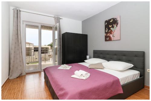 1 dormitorio con 2 camas y ventana grande en M&Z Apartmani, en Primošten