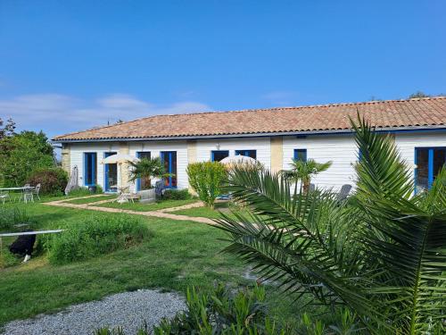 Casa blanca con ventanas azules y patio en La Cadournaise, en Saint-Seurin-de-Cadourne
