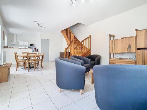 un salon avec des chaises bleues et une table dans l'établissement Gorges du Tarn gîte en pierres avec terrasse, à Quézac