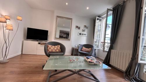 - un salon avec deux chaises et une table en verre dans l'établissement Charmant apartment in Monmartre, à Paris
