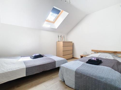 une chambre avec deux lits et une commode dans l'établissement Gorges du Tarn gîte en pierres avec terrasse, à Quézac